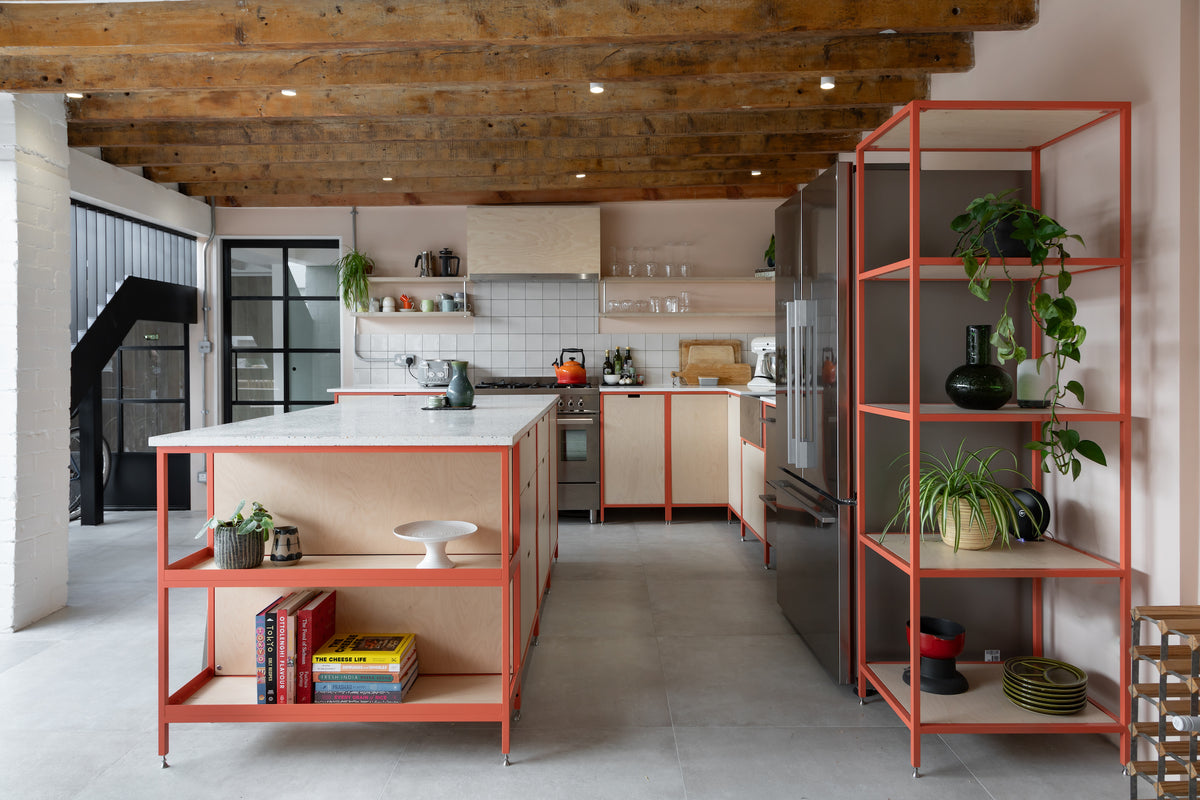open plan bespoke kitchen in pink metal frame work, open shelves and birch plywood fronts