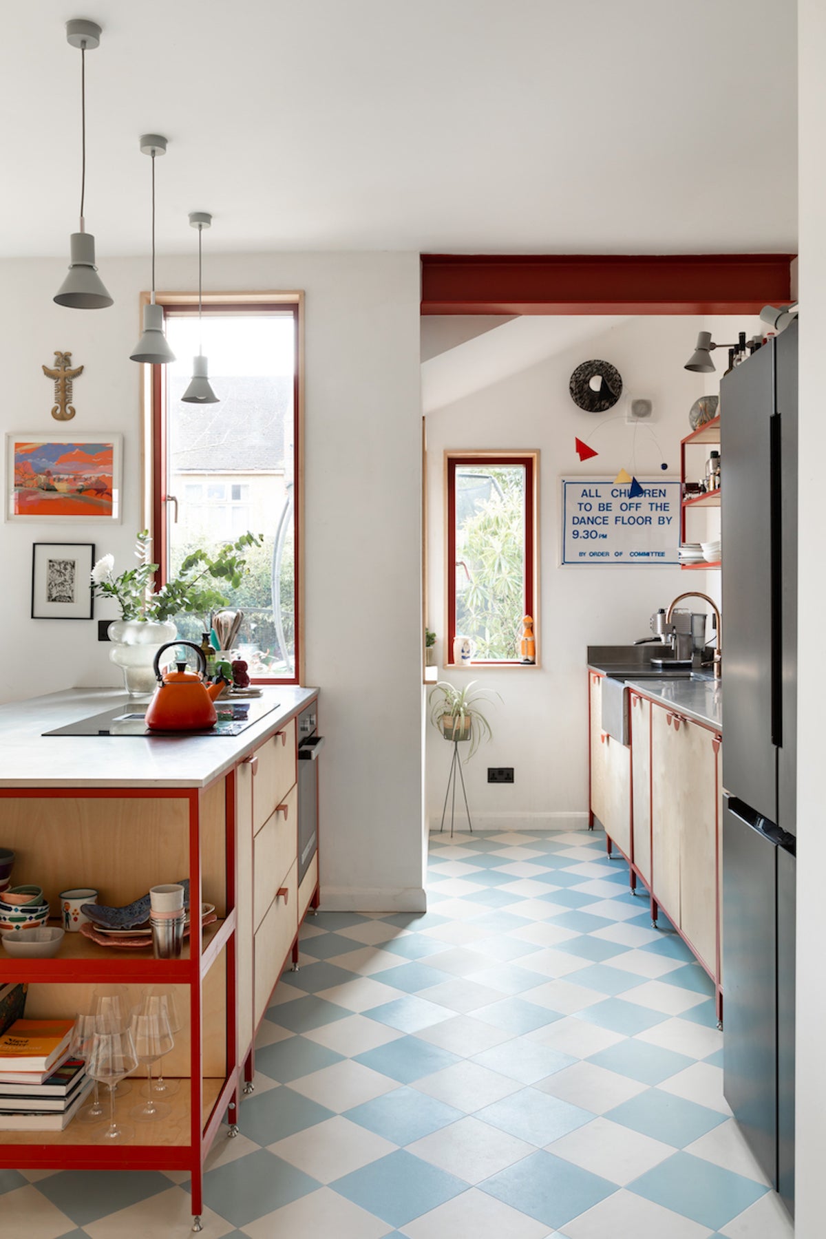 Steel frame kitchen in powder-coated frame work. red steel beam and baby blue checkerboard floor 