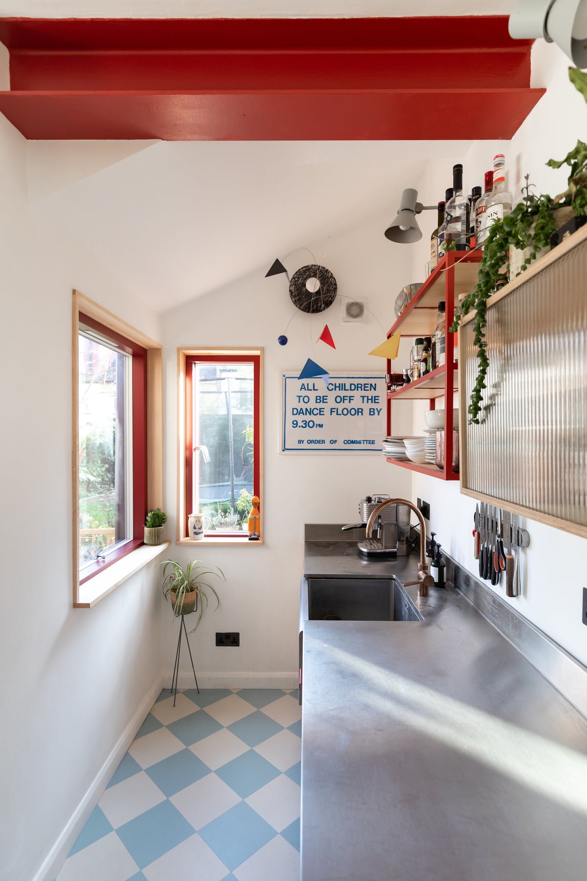 Red steel beam, baby blue checkerboard floor tiles, stainless steel worktop 