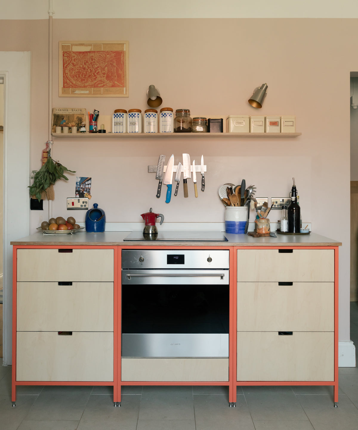 Free-standing steel frame kitchen, in coral, orange. birch plywood fronts 